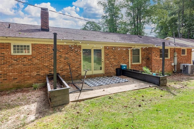 rear view of property with central AC, a patio area, and a lawn