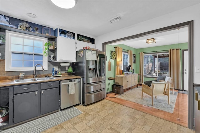 kitchen featuring a sink, visible vents, white cabinets, appliances with stainless steel finishes, and open shelves