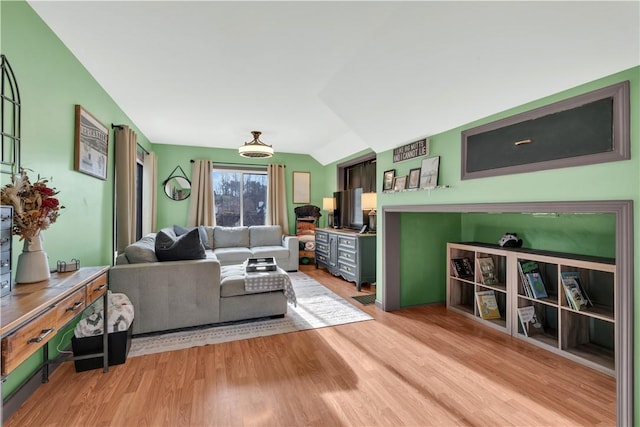 living room with light wood-style floors and vaulted ceiling