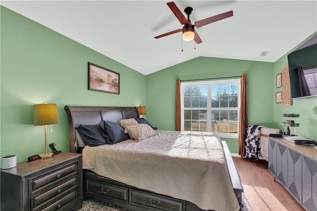 bedroom with vaulted ceiling, light wood finished floors, visible vents, and a ceiling fan