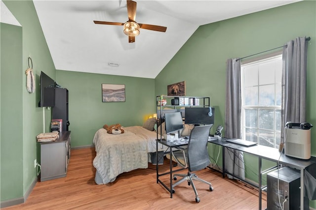 bedroom with light wood-type flooring, baseboards, and vaulted ceiling