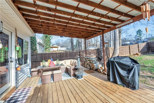 wooden deck featuring a fenced backyard, a grill, and an outdoor living space