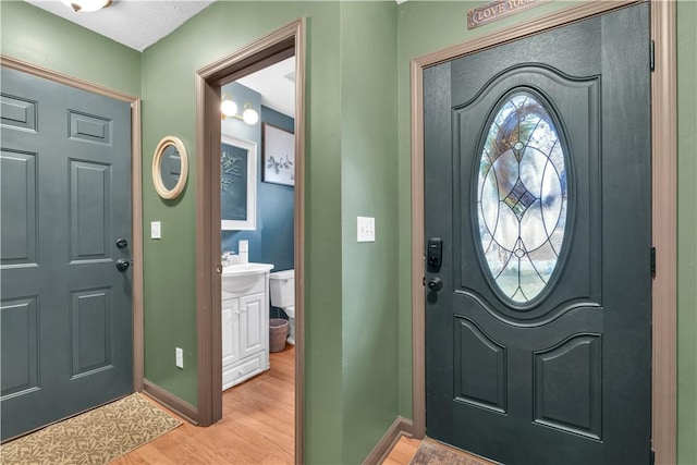 entryway with light wood finished floors and baseboards