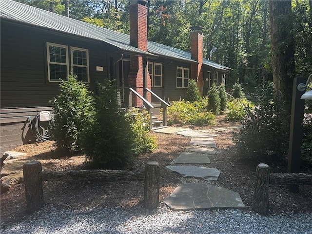 exterior space with metal roof and a chimney