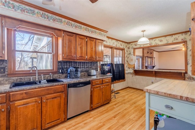 kitchen featuring pendant lighting, sink, dishwasher, plenty of natural light, and ornamental molding