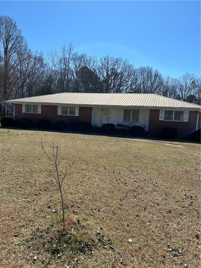 single story home featuring a front yard and brick siding