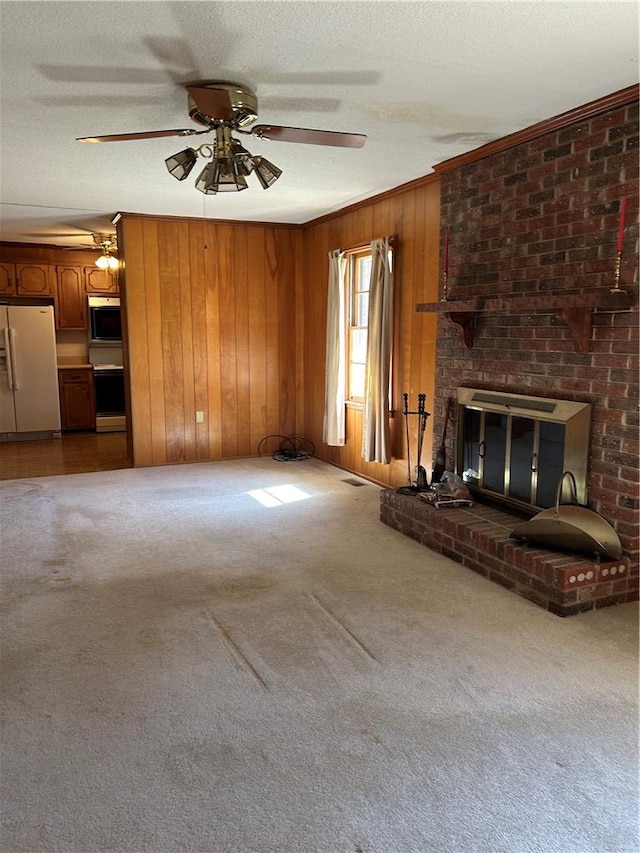 unfurnished living room with carpet flooring, wood walls, and a textured ceiling