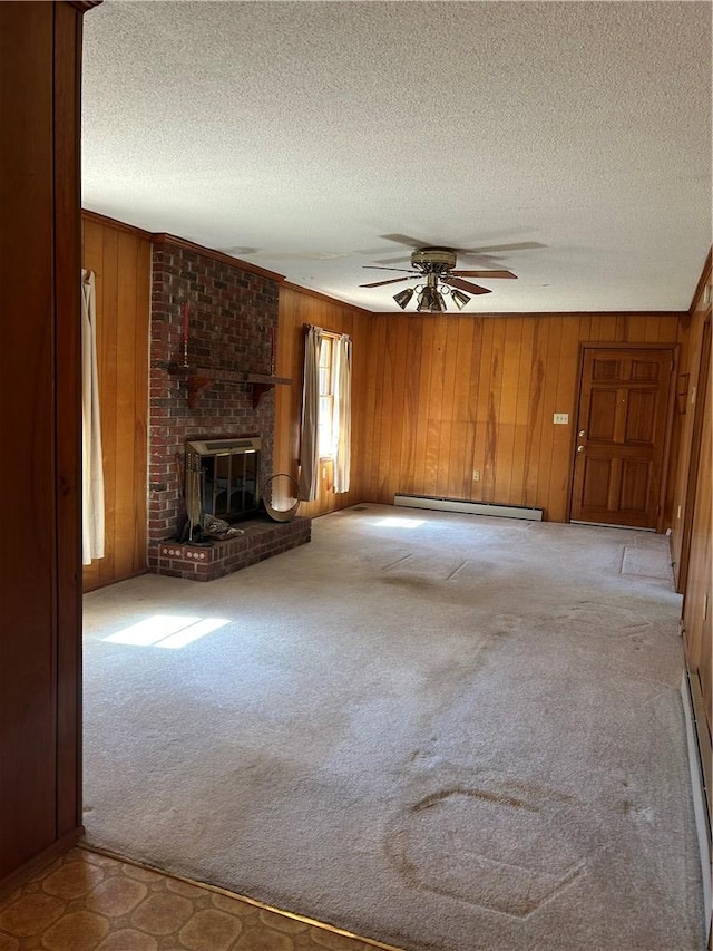 unfurnished living room featuring a baseboard heating unit, light colored carpet, a fireplace, and wood walls