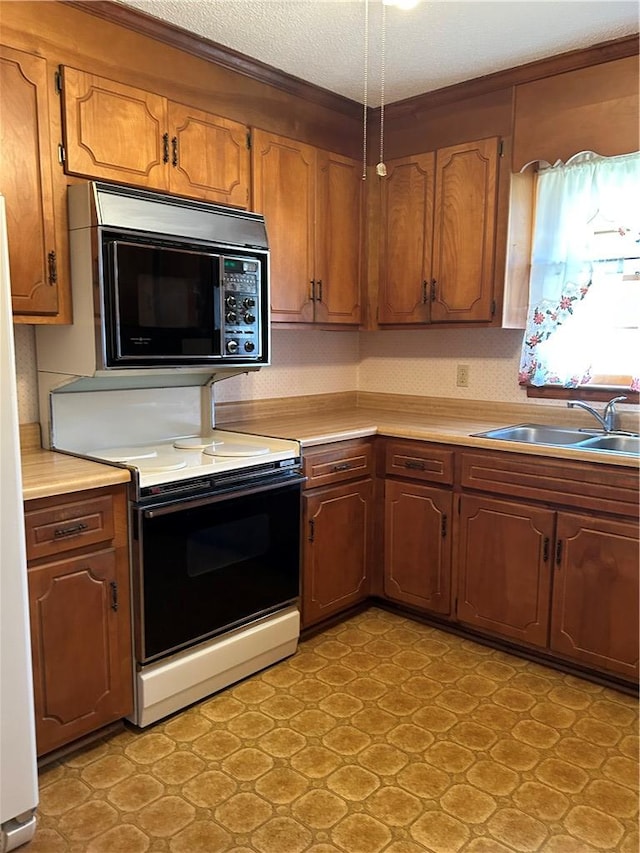 kitchen featuring brown cabinets, white appliances, light countertops, and a sink