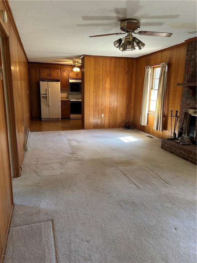 unfurnished living room featuring light carpet, wood walls, crown molding, and a textured ceiling