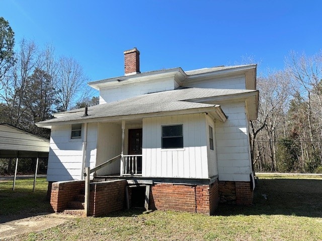 rear view of house with a carport and a lawn