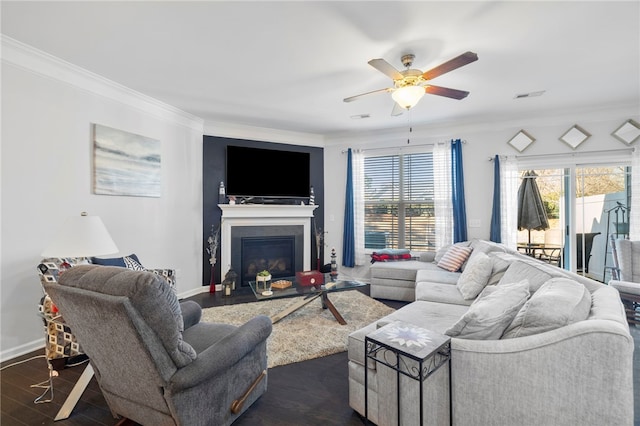 living room with dark hardwood / wood-style flooring, ceiling fan, and crown molding