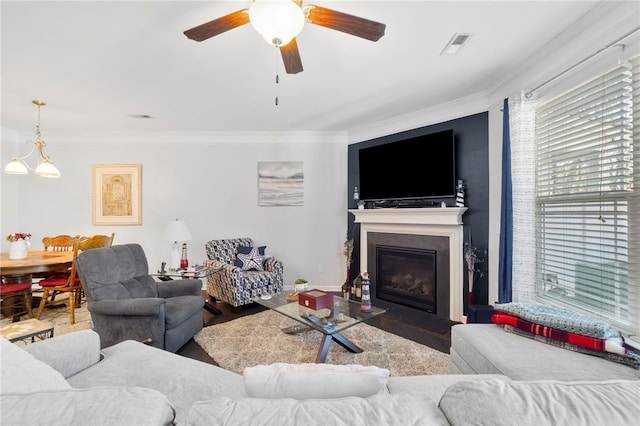 living room with ornamental molding and ceiling fan