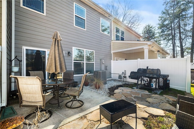 rear view of property with central AC unit and a patio