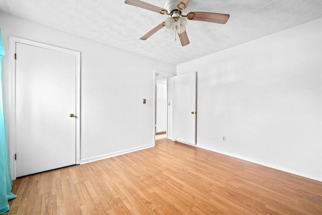 unfurnished bedroom featuring ceiling fan, light hardwood / wood-style floors, and a textured ceiling