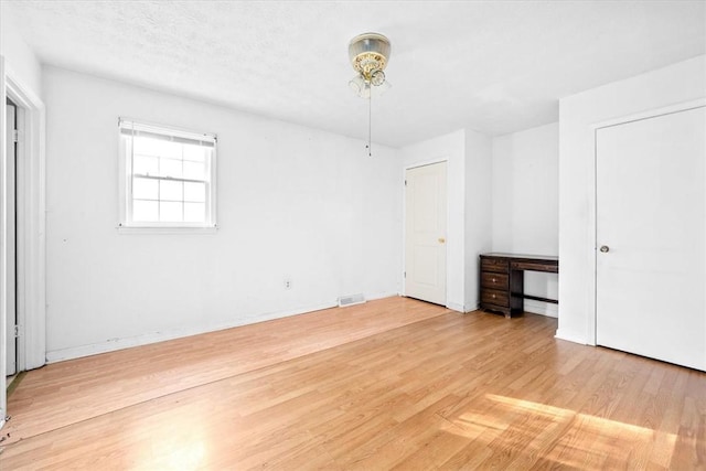 unfurnished bedroom featuring a textured ceiling and hardwood / wood-style flooring