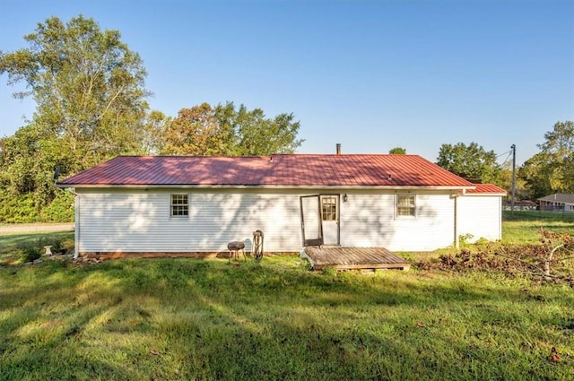 rear view of house featuring a lawn and a deck