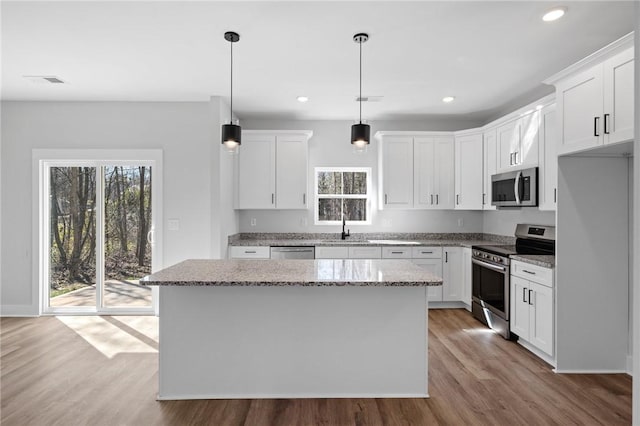 117 Norbert Ln, Anderson, SC 29624 - kitchen featuring appliances with stainless steel finishes, a kitchen island, white cabinetry, and decorative light fixtures