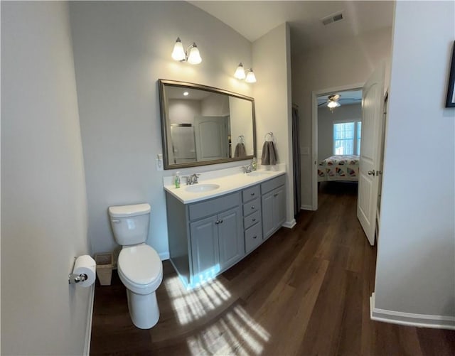 bathroom featuring toilet, vanity, and wood-type flooring