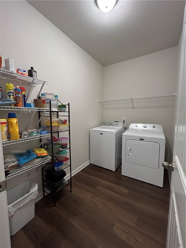 washroom with washing machine and clothes dryer and dark hardwood / wood-style flooring