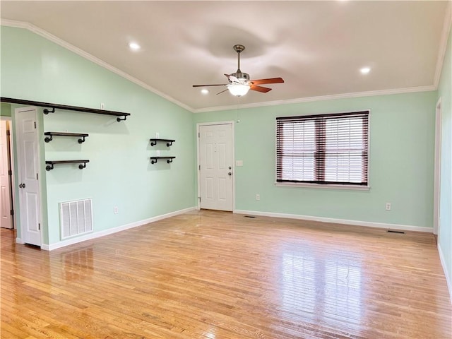 empty room with ceiling fan, ornamental molding, light wood-type flooring, and lofted ceiling