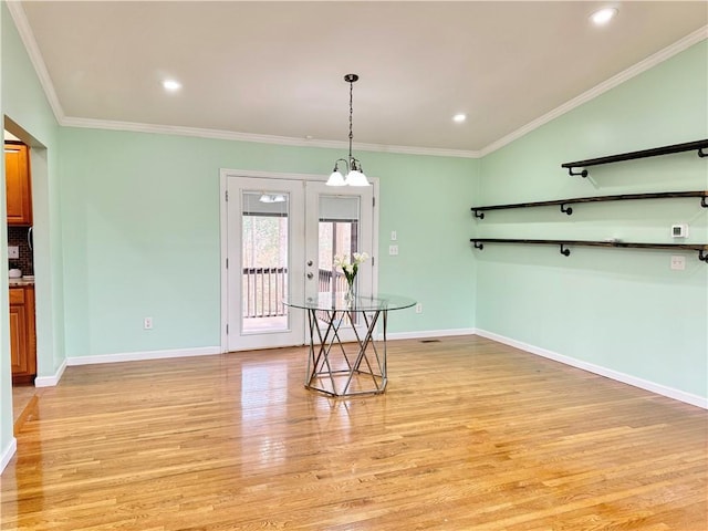 dining area featuring ornamental molding, light hardwood / wood-style floors, and french doors