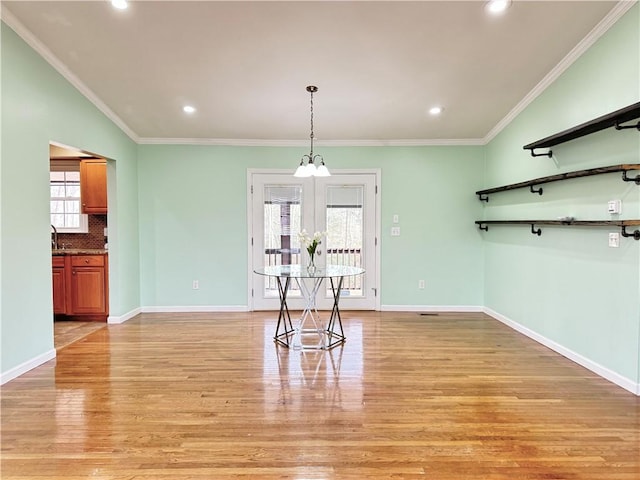 unfurnished dining area with sink, ornamental molding, light hardwood / wood-style floors, and french doors