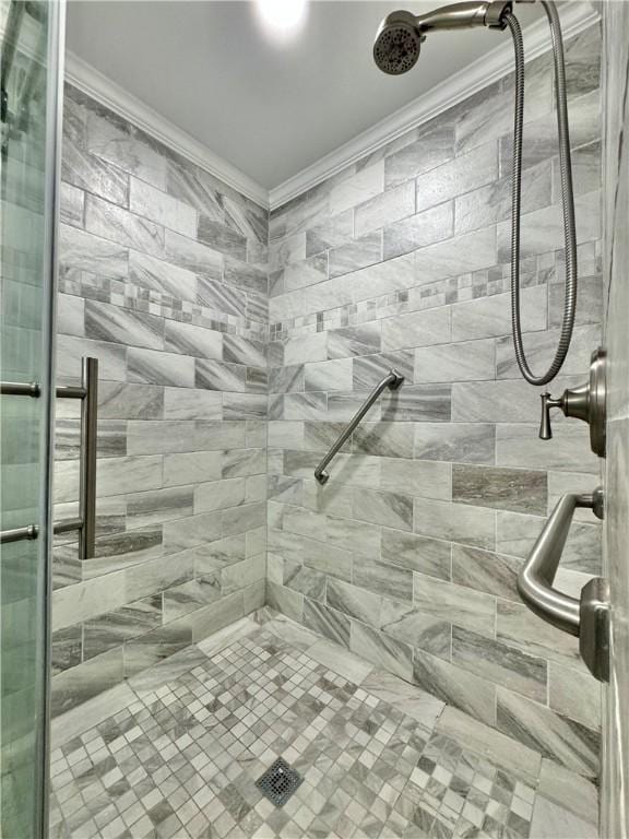 bathroom with ornamental molding and a shower with door