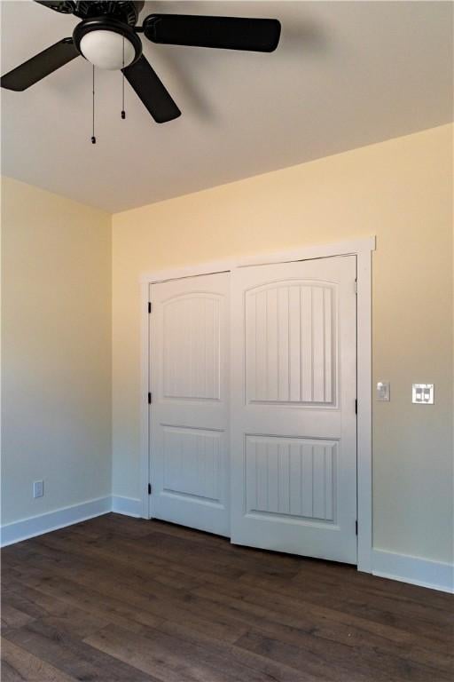 unfurnished bedroom featuring a closet, dark hardwood / wood-style floors, and ceiling fan