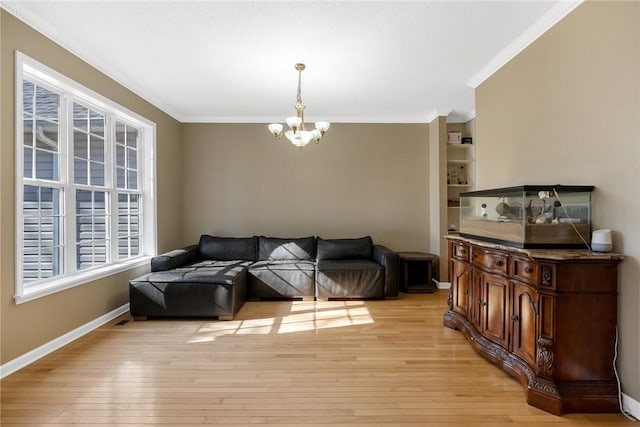 living room with light wood-type flooring, an inviting chandelier, and ornamental molding