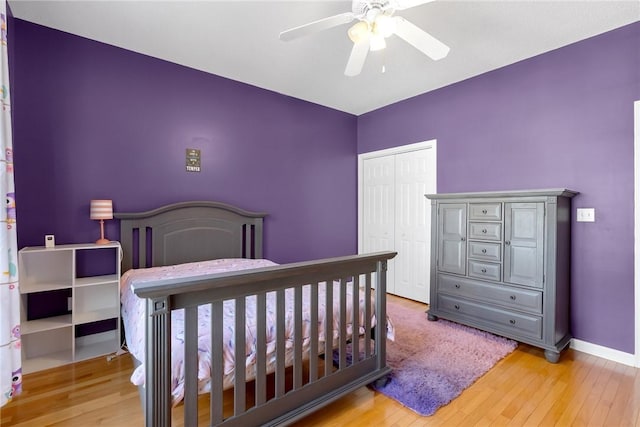 bedroom with ceiling fan, a closet, and light hardwood / wood-style floors