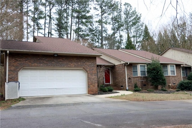 ranch-style home with brick siding, a shingled roof, an attached garage, crawl space, and driveway