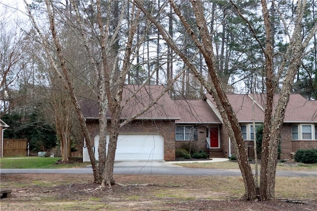 ranch-style home featuring a shingled roof, concrete driveway, brick siding, and an attached garage