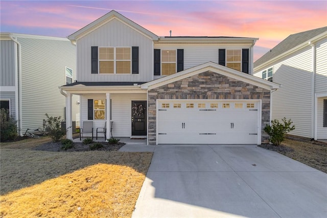 front of property featuring a porch, a garage, and a lawn