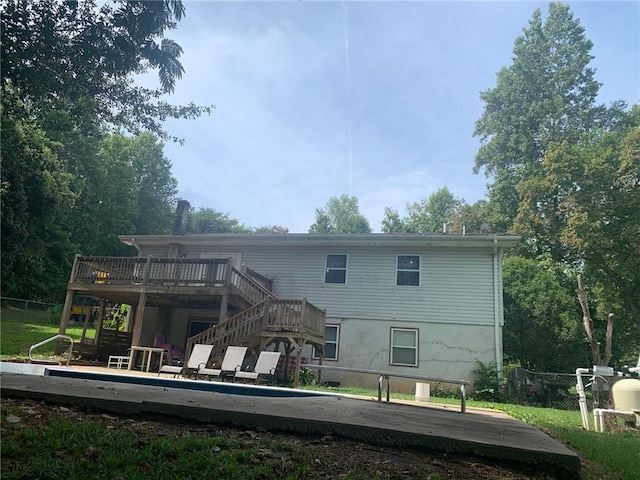 back of house featuring stairs, a wooden deck, and fence