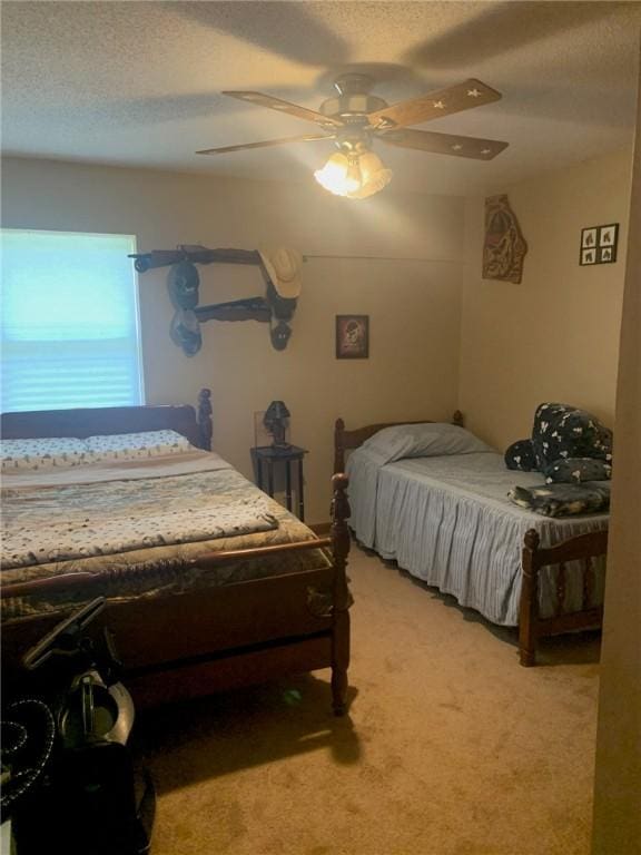 bedroom with light carpet, a ceiling fan, and a textured ceiling