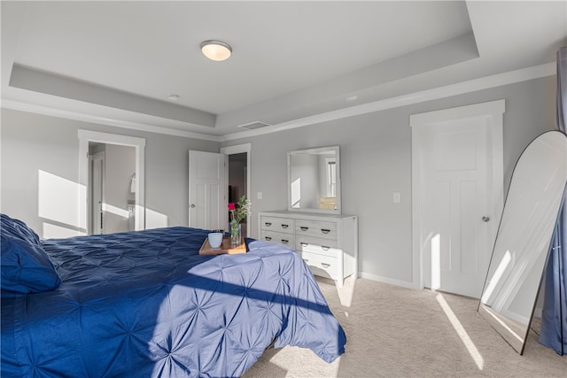 carpeted bedroom with a tray ceiling and ornamental molding