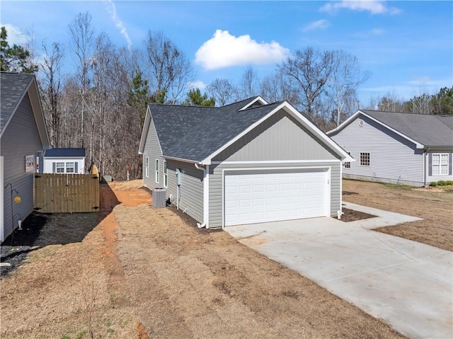 view of side of property with a garage and central air condition unit