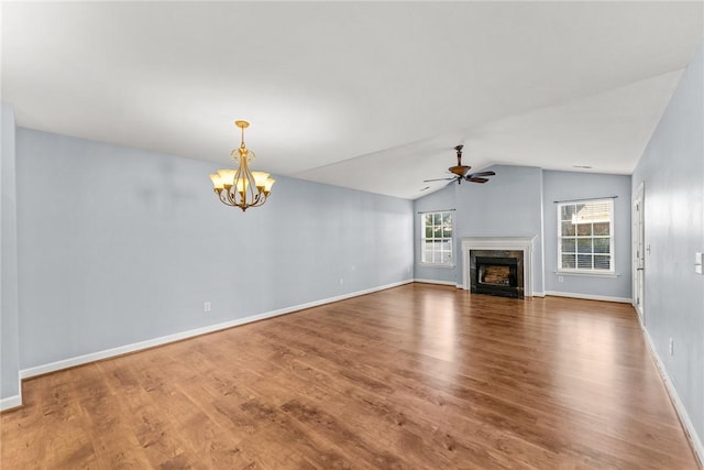 unfurnished living room featuring ceiling fan with notable chandelier, lofted ceiling, a high end fireplace, and hardwood / wood-style floors