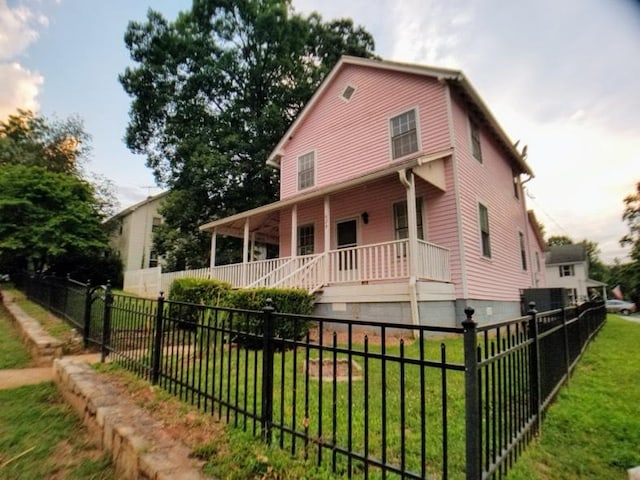 view of front of home with covered porch and a front lawn