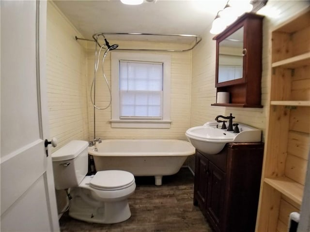 bathroom with toilet, vanity, a bathtub, and hardwood / wood-style floors