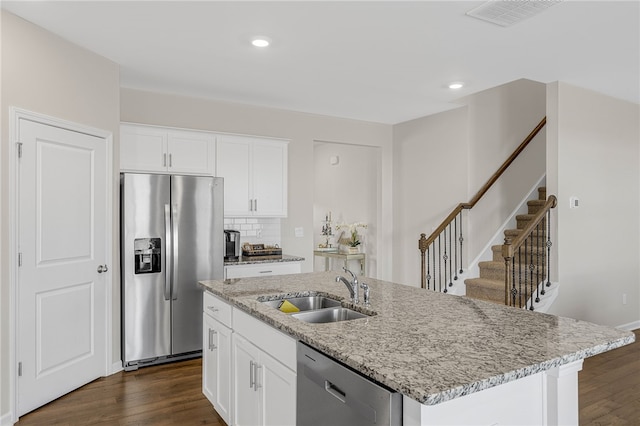 kitchen with sink, stainless steel appliances, white cabinetry, and an island with sink