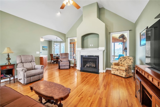 living room featuring high vaulted ceiling, light hardwood / wood-style floors, a wealth of natural light, and ceiling fan