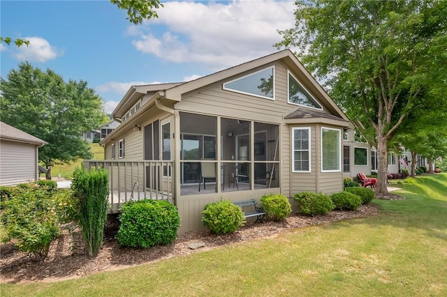 view of side of home with a sunroom and a yard