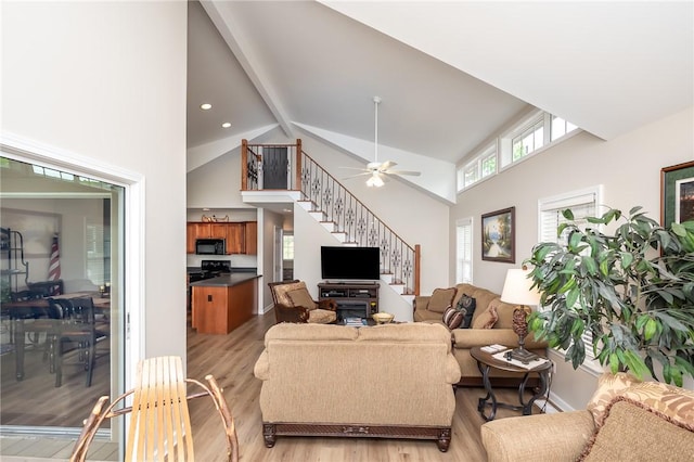 living room with high vaulted ceiling, light hardwood / wood-style floors, ceiling fan, and beam ceiling