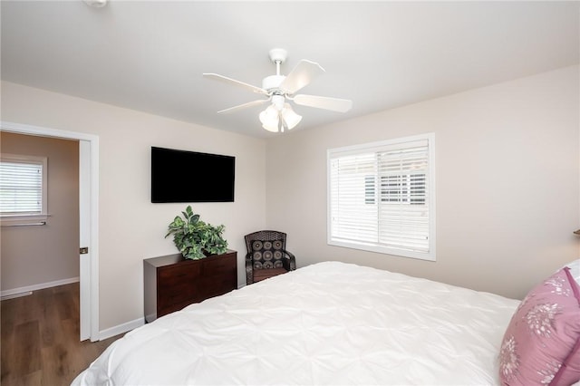 bedroom featuring hardwood / wood-style floors, ceiling fan, and multiple windows