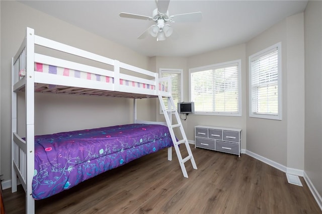 bedroom with dark hardwood / wood-style flooring and ceiling fan