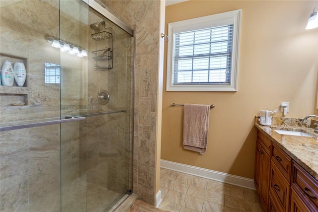 bathroom featuring a shower stall, vanity, and baseboards