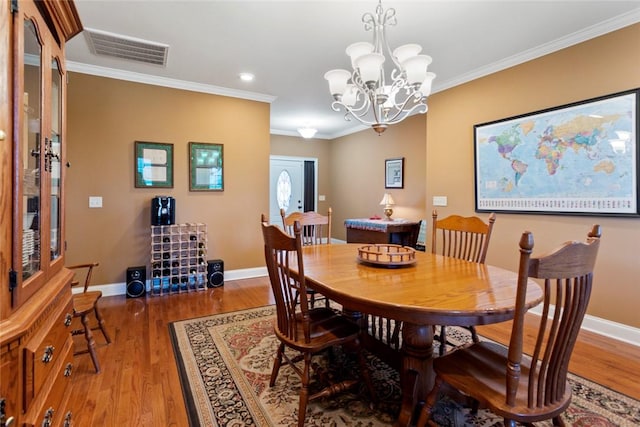 dining room with dark wood-style flooring, visible vents, and crown molding