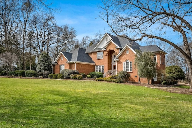 traditional-style house with crawl space, brick siding, and a front lawn